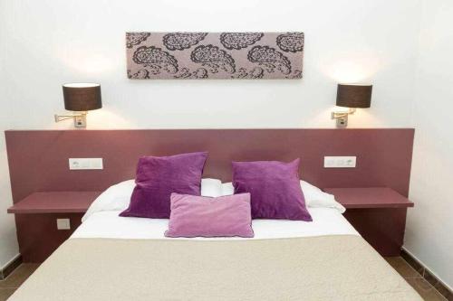 a bedroom with a bed with purple pillows at Port III Apart céntrico ideal familias 11 in Barcelona