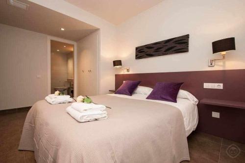 Dos camas en una habitación de hotel con toallas. en Port IV Apart céntrico ideal grupos 12 en Barcelona