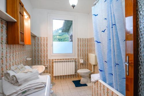 baño con lavabo y aseo y ventana en La casa di Leo, en Riccò del Golfo di Spezia