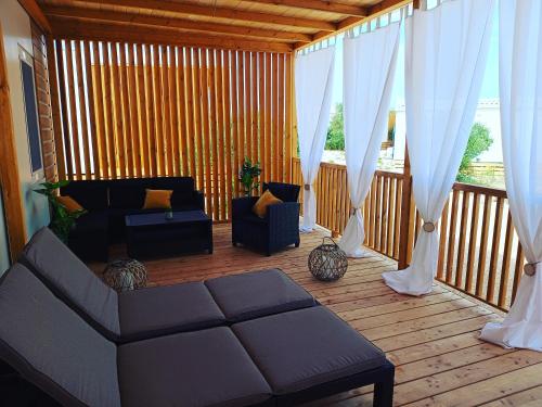 a living room with a couch and curtains on a deck at Mobile Home Drage in Drage