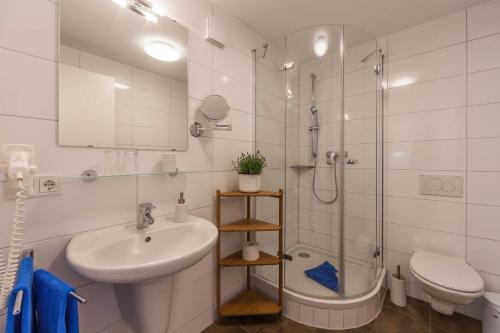 a bathroom with a sink and a shower and a toilet at Seehotel BelRiva in Hagnau
