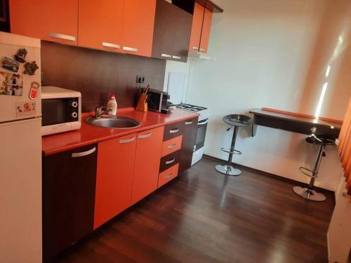 una pequeña cocina con fregadero y microondas en Apartament cu parcare privata en Arad