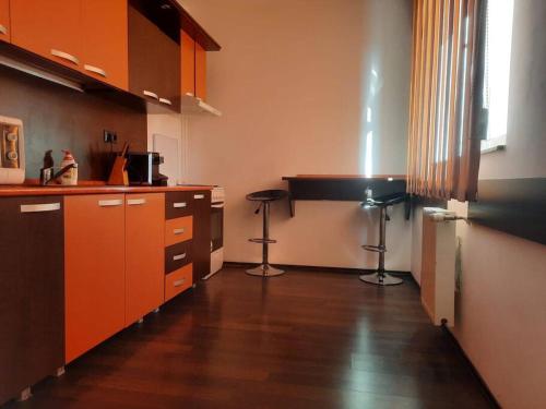 a kitchen with orange cabinets and a wooden floor at Apartament cu parcare privata in Arad