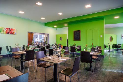 a restaurant with tables and chairs and green walls at iH Hotels Milano Lorenteggio in Milan