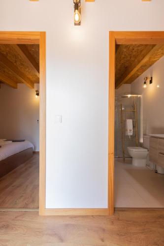 a room with a bathroom with a toilet and a bed at HUGS Nature Retreat Heated Pool & Jacuzzi in Vila Verde
