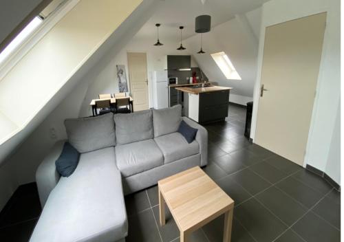 een woonkamer met een bank en een tafel bij L’apparté, meublé de tourisme in Saint-Folquin