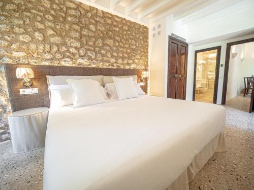 a large white bed in a room with a wall at Ca'n Puig de Sòller in Sóller