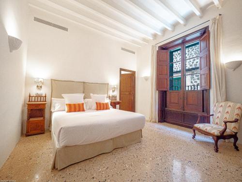 a bedroom with a bed and a chair and a window at Ca'n Puig de Sòller in Sóller