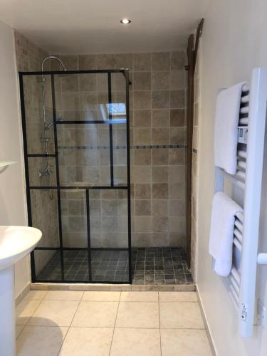 W łazience znajduje się prysznic ze szklanymi drzwiami. w obiekcie Le Domaine de Toussacq w mieście Villenauxe-la-Petite
