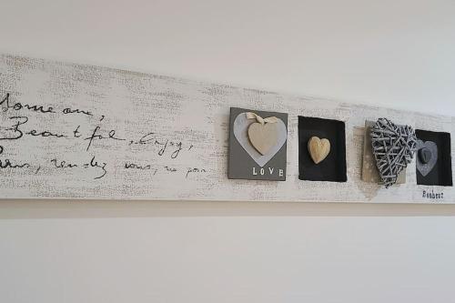 a shelf with pictures of hearts and writing on a wall at 7 couchages aux portes des célèbres Parfumeries WIFI in Grasse