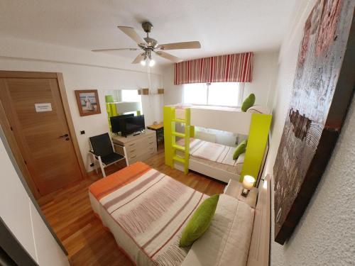 - une chambre avec un lit et un canapé ainsi qu'une chambre avec une télévision dans l'établissement Alojamientos Pamplona, à Pampelune
