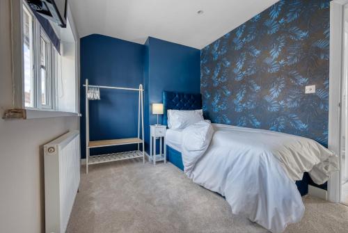 Dormitorio azul con cama y pared azul en Viewtopia House en Whittington