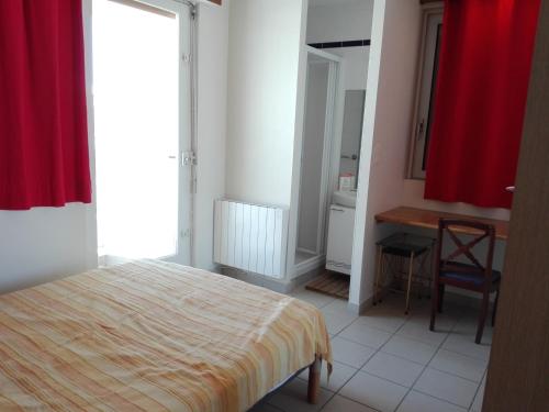 une chambre avec un lit et un rideau rouge dans l'établissement Appartement T2 face plage - Les Sables-d'Olonne - FR-1-331-22, à Les Sables-dʼOlonne