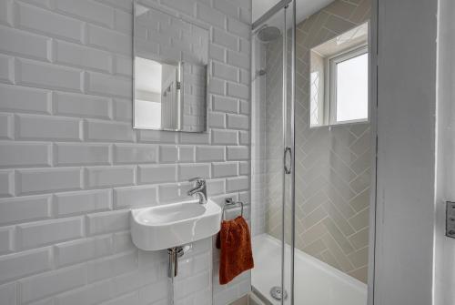 a white bathroom with a sink and a shower at Viewtopia House in Whittington