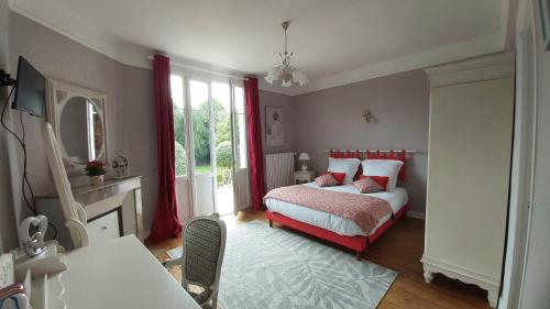 - une chambre avec un lit doté de rideaux rouges et d'une cheminée dans l'établissement La Villa des Tilleuls, à Cambremer