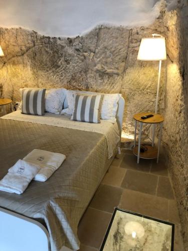 a bedroom with a bed in a stone wall at Cà Giò in Ostuni