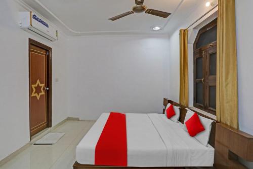 a bedroom with a bed with red pillows and a ceiling at OYO Flagship Premium rooms in New Delhi