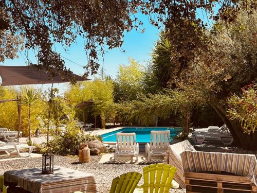 a group of chairs and a swimming pool at Casa Rico Frade Garden in São Pedro do Corval