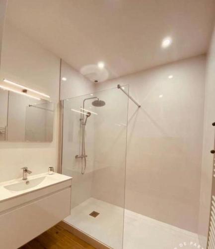 une salle de bain blanche avec une douche et un lavabo dans l'établissement LOCATION MAISON LES PIEDS DANS L'EAU - 8 personnes, à Arcachon