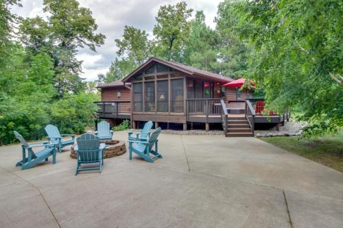 a log cabin with blue chairs in front of it at Beautiful Breezy Point Home with Beach and Dock! in Pequot Lakes