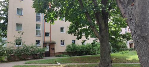 a building with a tree in front of it at Warszawa Wola Pokoje in Warsaw