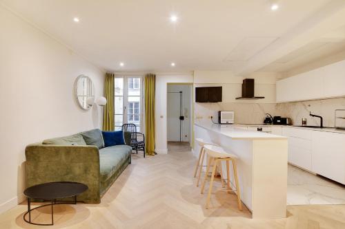 un salon et une cuisine avec un canapé et une table dans l'établissement Pick A Flat's Apartment in Triangle d'Or - Rue Penthievre, à Paris