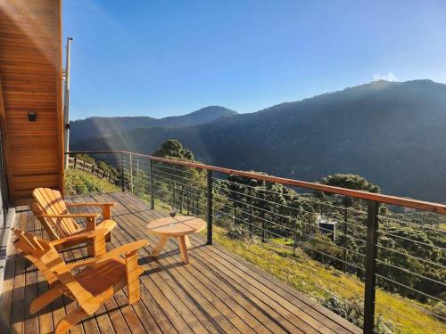 a balcony with two chairs and a table and a view at Chalé Rosa Vermelha in Urubici