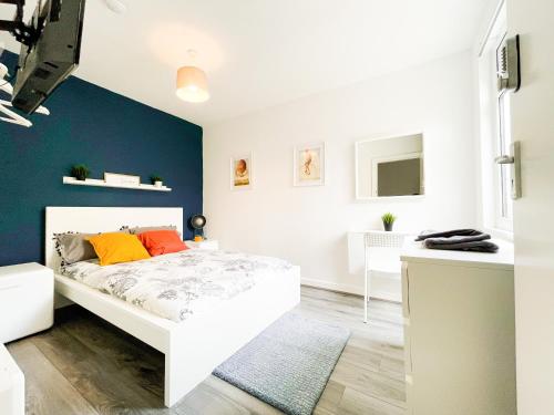 1 dormitorio con cama blanca y pared azul en Convenient Shared Living Near City Center en Liverpool