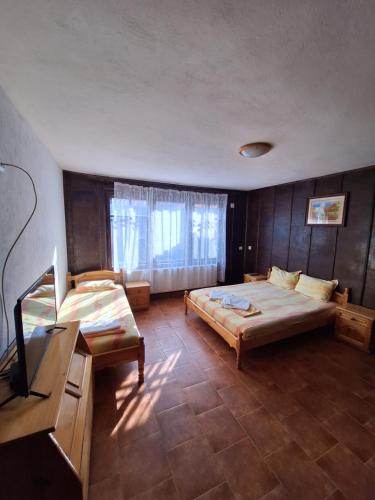 um quarto com duas camas e uma televisão em Къща за гости Бащин дом em Apriltsi