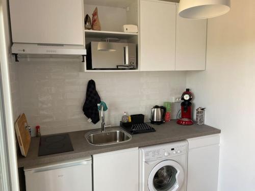 a kitchen with a sink and a washing machine at Ramonville parking Privé balcon café in Ramonville-Saint-Agne