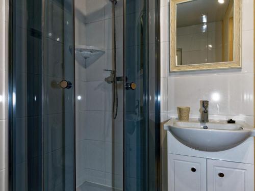 a bathroom with a sink and a shower with a mirror at Holiday house in Pobierowo for 4 people near the sea in Pobierowo