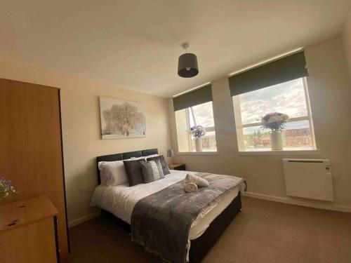 - une chambre avec un grand lit et 2 fenêtres dans l'établissement Cozy Haven: Charming Retreat, à Manchester
