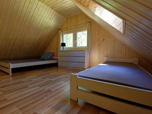 a attic room with a bed and a window at Holiday house in Pobierowo for 5 people near the sea in Pobierowo