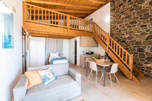 a living room with a staircase and a couch and a table at Enastron Apartments in Sitia