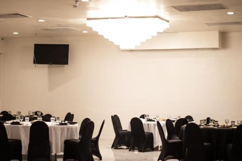a conference room with tables and chairs and a tv at Hotel Americana in Nogales