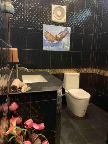 a bathroom with a toilet and a sink at Ban Aob Maiy(บ้านโอบไม้) in Ban Si Wicha