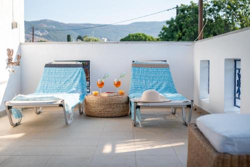 a patio with two chairs and two tables on a balcony at To Pyrgaki Kos in Kos Town