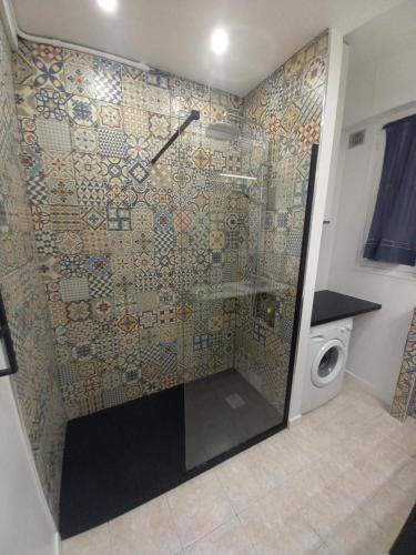une douche dans une salle de bain avec machine à laver dans l'établissement Le Catinat, à Nice