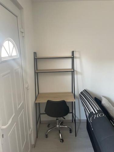 a bedroom with a desk and a chair next to a bed at Charmant appartement avec parking privée in Buxerolles