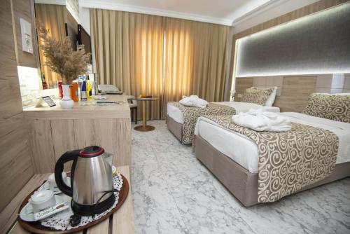 a hotel room with two beds and a tea kettle at Afyon MCG Marble Hotel in Afyon