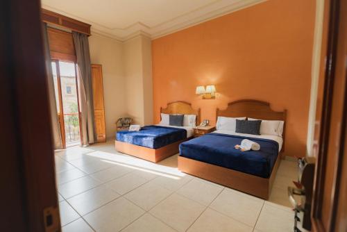 a hotel room with two beds and a window at Hotel Santiago De Compostela - Guadalajara Centro Historico in Guadalajara