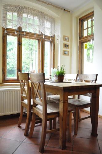 a dining room with a wooden table and chairs at Villa Hubertus in Srebrna Góra