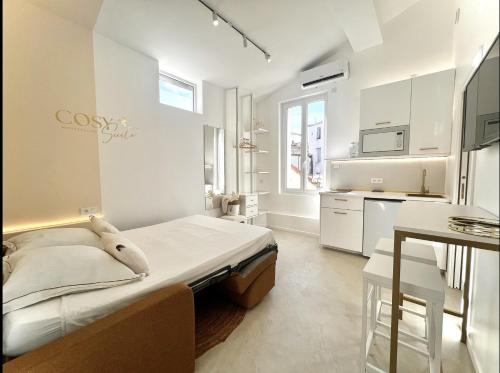 Cette chambre blanche dispose d'un lit et d'une cuisine. dans l'établissement Cosy Suite - Élégance & Calme en Hyper-Centre, à Montpellier