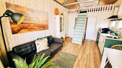 a living room with a couch and a kitchen at Kusthuisjes in Katwijk
