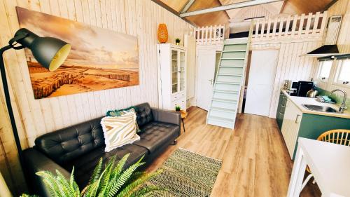 a living room with a couch and a kitchen at Kusthuisjes.nl in Katwijk