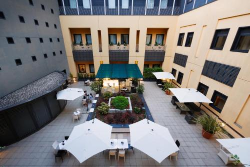 an overhead view of a courtyard with tables and umbrellas at iH Hotels Milano Gioia in Milan