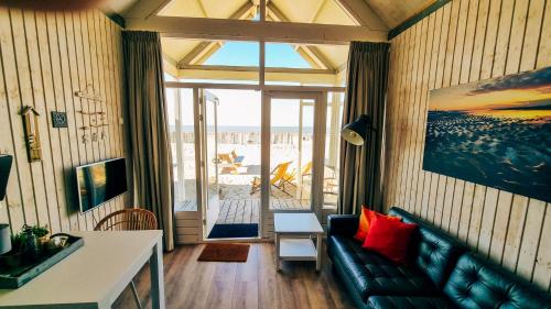 a living room with a couch and a view of the ocean at Kusthuisjes in Katwijk