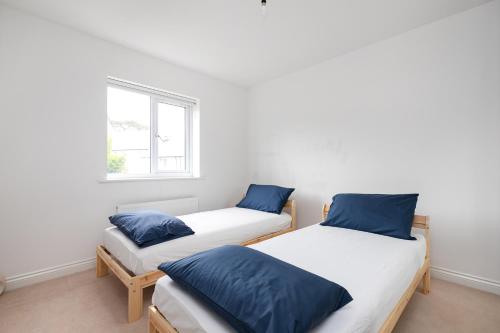 two twin beds in a room with a window at Stunning 5-Bed House in Ashford in Ashford