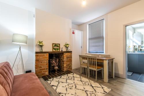 a living room with a fireplace and a table and chair at Warburton House, Newark - Walking distance from North Gate Train Station & Market Place in Newark upon Trent