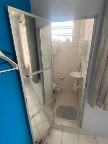 uma pequena casa de banho com um chuveiro e um lavatório. em Quarto Suíte Orla Salvador BA em Salvador